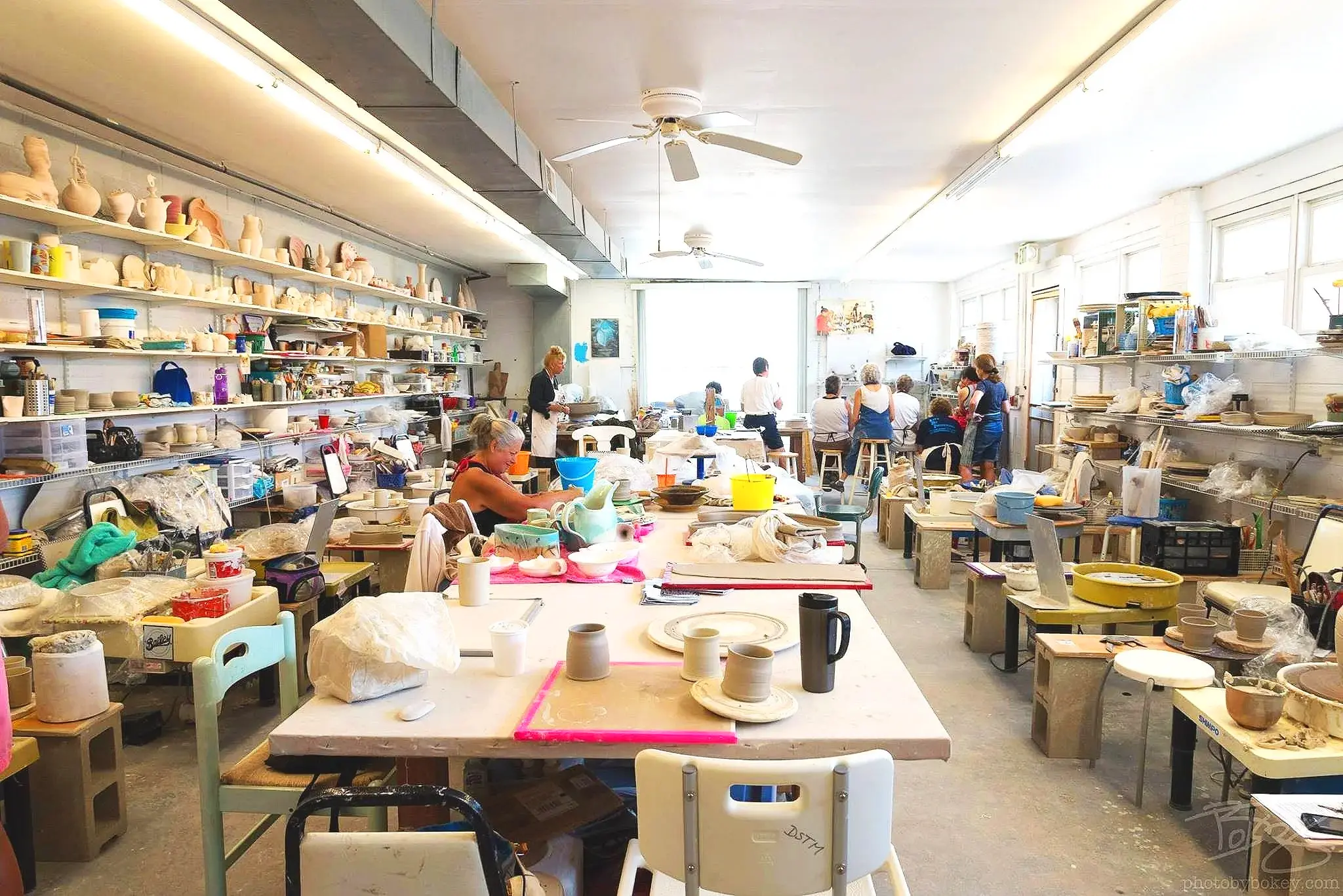 Artists working in the Long Beach Island Foundation ceramics studio surrounded by pottery and tools.