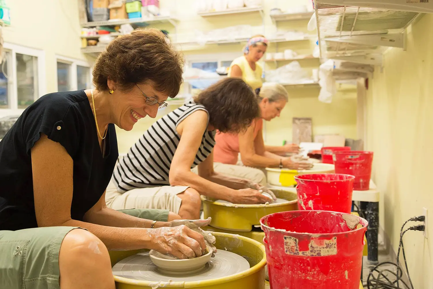 Participants at LBIF’s ceramics studio shaping clay on pottery wheels during a class session.