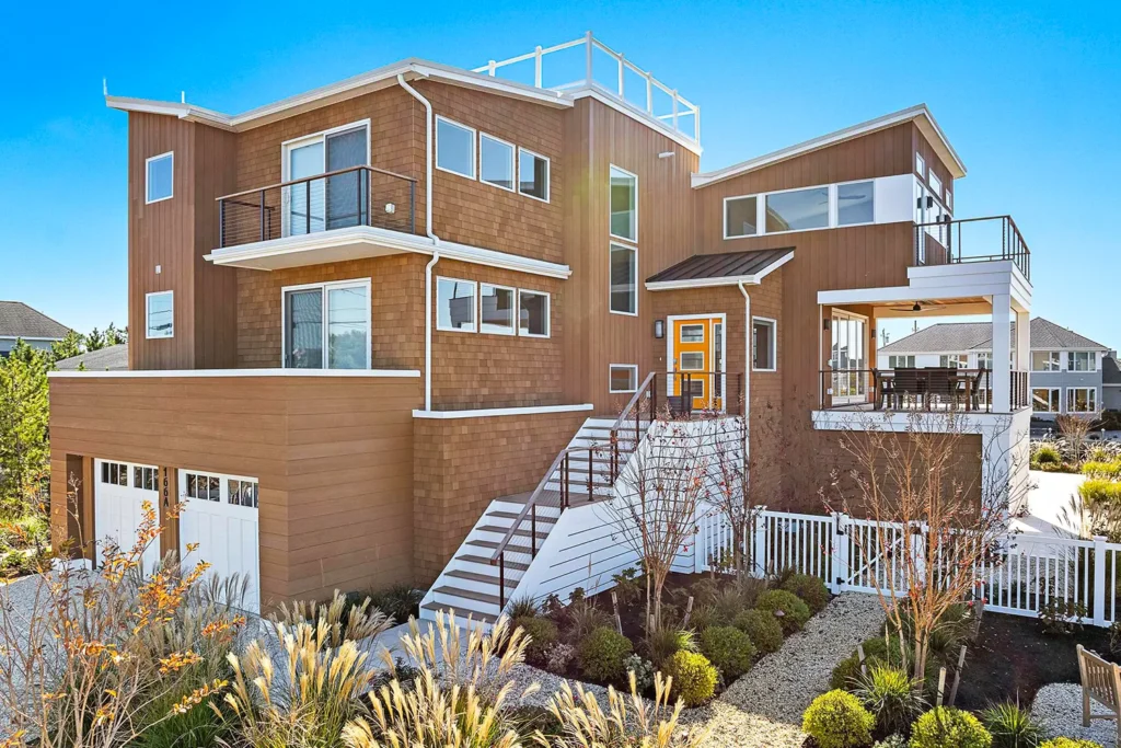 Modern coastal home with cedar siding, white trim, and multiple balconies, featured in the 2025 LBIF Annual Seashore House Tour.