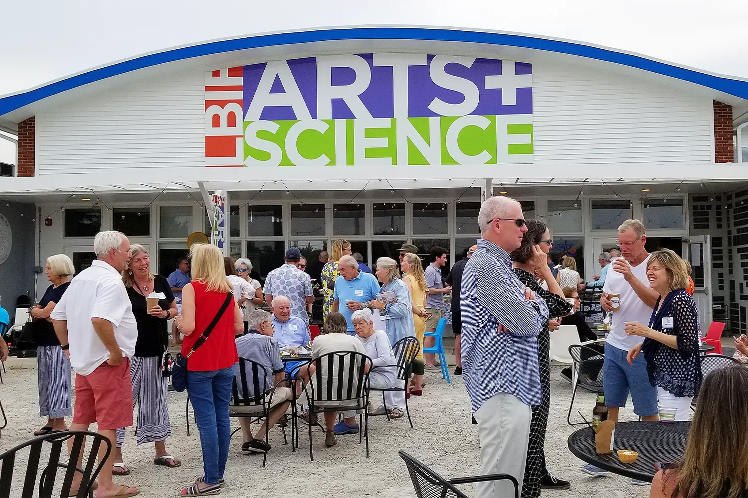 Guests mingle and socialize outdoors in front of the LBIF Arts + Science building during a community event.
